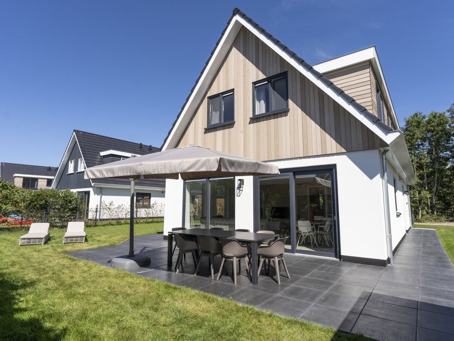 Villa 19 in De Koog, Texel, bietet eine geraeumige Terrasse mit modernen Sitzgelegenheiten, ideal fuer Sommerabende auf den Watteninseln.