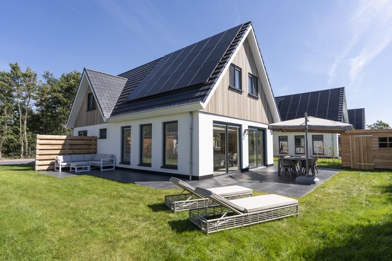 Geniessen Sie die Sonne auf dem gruenen Rasen und der Terrasse der Villa 19, einem Ferienhaus in De Koog, Texel, umgeben von Natur.