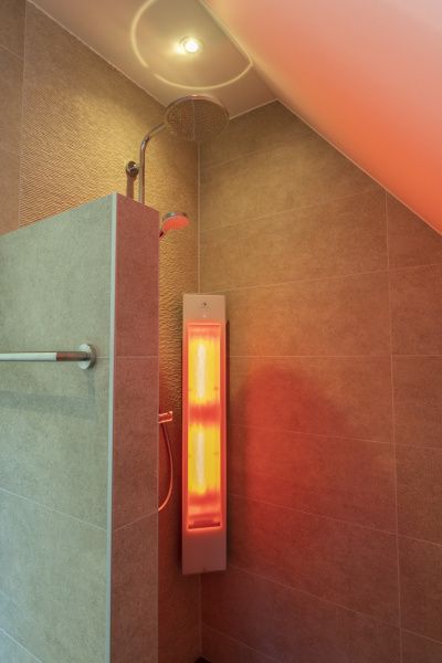 Moderne Dusche in Villa 19, De Koog, Texel mit stimmungsvoller Beleuchtung, ideal fuer einen erfrischenden Start in den Tag.