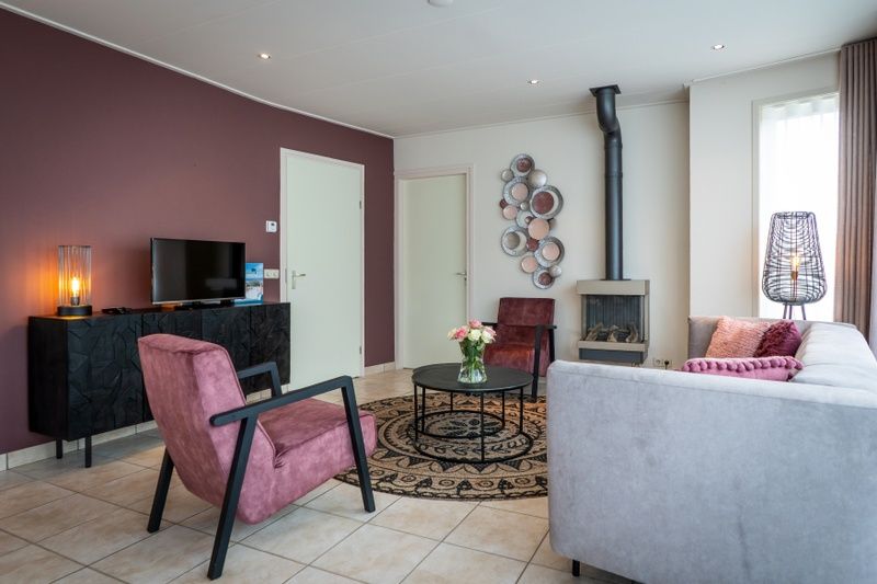 Stilvolles Wohnzimmer von Bungalow 31 in De Koog, Texel mit Kamin und modernen Moebeln fuer einen gemuetlichen Urlaub.