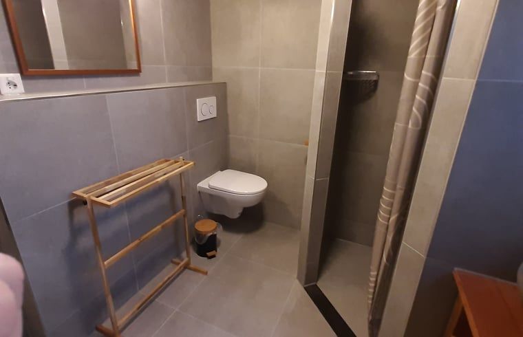 Cozy corner with closet and chair in Cottage in De Koog, Texel, ideal for relaxing moments.