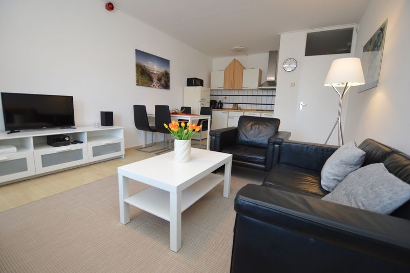 Stylish interior space of Apartment Kerckeland 98, De Koog, Texel with dining and sitting area for a relaxing stay.