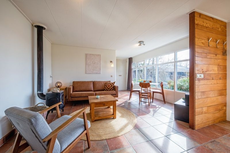 Innenraum des Ferienhauses De Zonneweelde in De Koog, Texel, mit gemuetlicher Sitzecke und viel Licht.