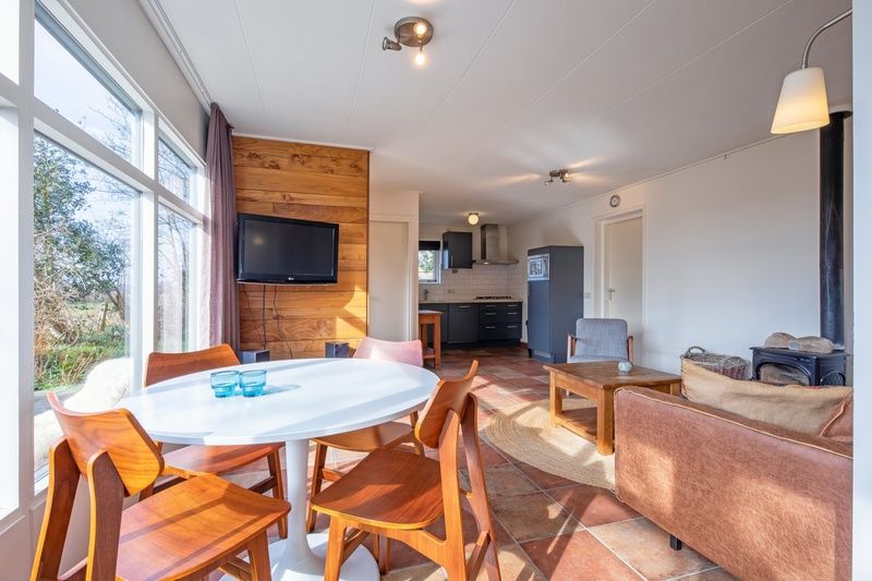 Essecke von De Zonneweelde in De Koog, Texel, mit rundem Tisch und Blick auf den Garten.