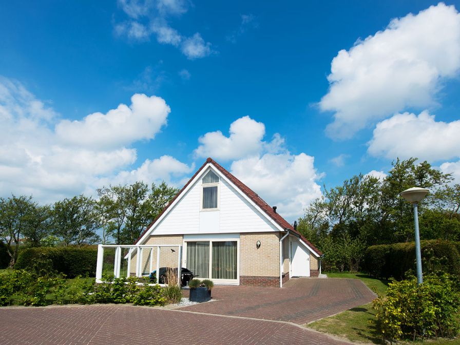 Villa 5 in De Koog, Texel, offers a charming vacation home with a beautiful garden and an inviting veranda.