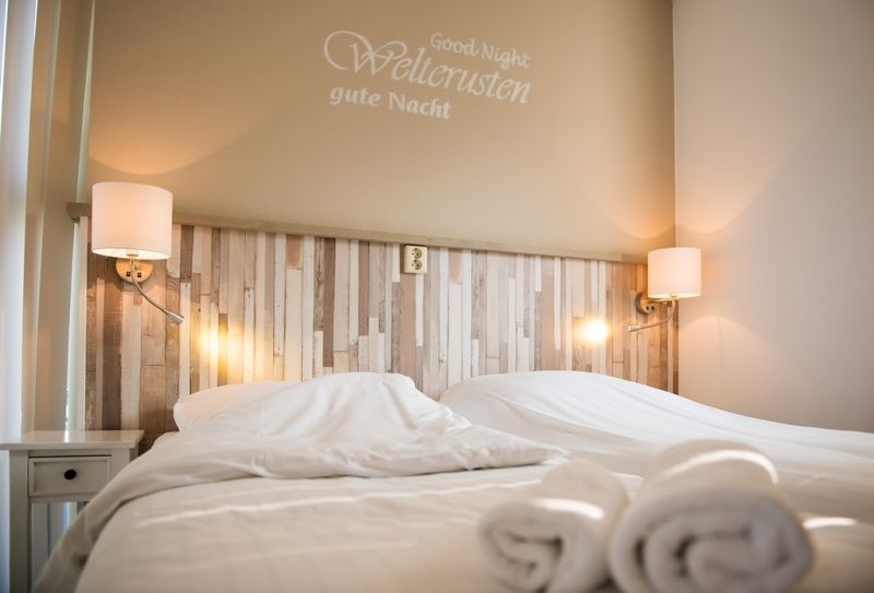 Cozy bedroom in Villa 5, De Koog, Texel, with comfortable beds and atmospheric lighting for a good night's sleep.