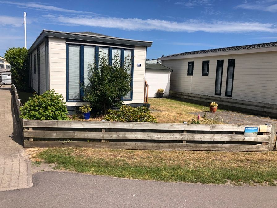 Chaletpark Bregkoog - Chalet Bregkoog 33, a charming vacation home in De Koog, Texel, with a cozy garden and wooden fence.