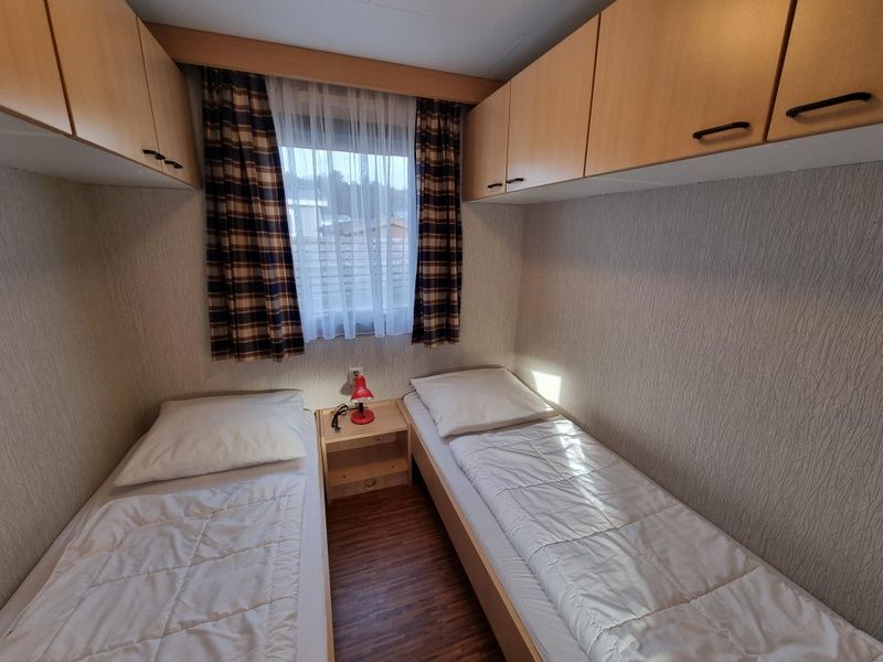 Cozy second bedroom in Chalet Bregkoog 33, Chaletpark Bregkoog, De Koog, Texel, with two single beds and plenty of storage space.