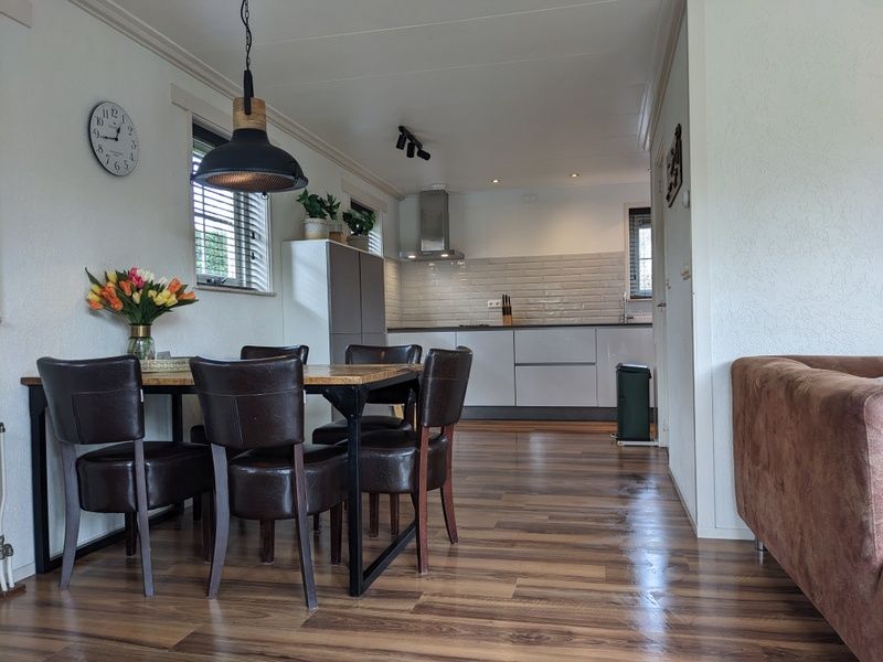 Dining area in D' Duinster vacation home, De Koog, Texel with wooden table and chairs on the Wadden Islands.
