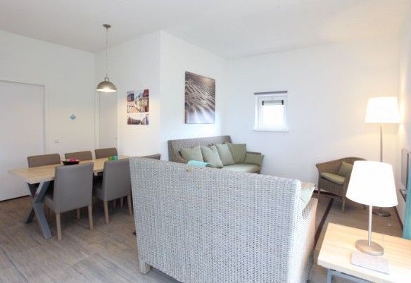 Cozy indoor area of Kustpark houses, De Koog, Texel, with comfortable seating and dining area for a cozy stay on the Wadden Islands.