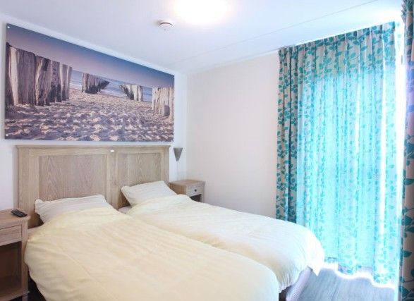 Attractive bedroom in Kustpark houses, De Koog, Texel, with beach decor and light for a restful night's sleep on the Wadden Islands.