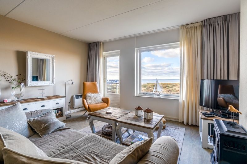 Helles Wohnzimmer im Appartement Juliana 116 Zeezicht, De Koog, Texel mit Blick auf die Duenen und das Meer.