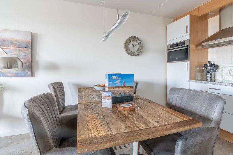 Essecke mit Holztisch im Appartement Juliana 116 Zeezicht, De Koog, Texel fuer gemuetliche Mahlzeiten.