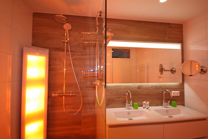 Moderne Dusche und Waschbecken im Apartment Juliana 116 Zeezicht, De Koog, Texel mit stimmungsvoller Beleuchtung.