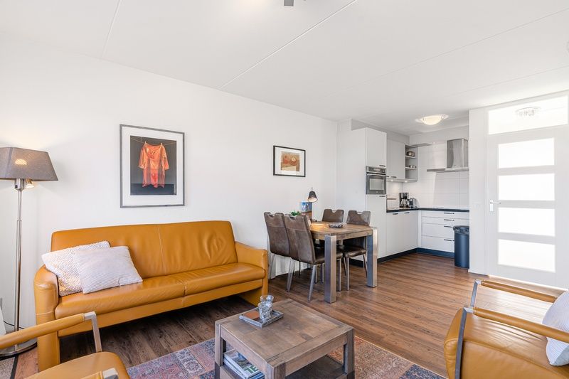 Dining area in Apartment Juliana 154 Zeezicht, De Koog, Texel with wooden table and leather chairs.