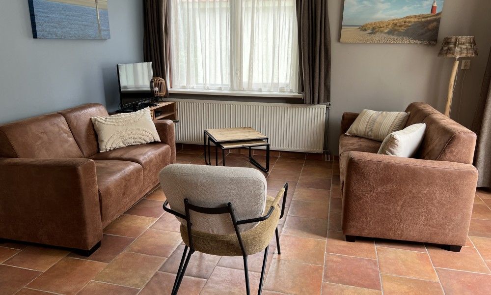 Modern kitchen in Koetshuis vacation home, De Koog, Texel, with wooden cabinets and views of green nature.