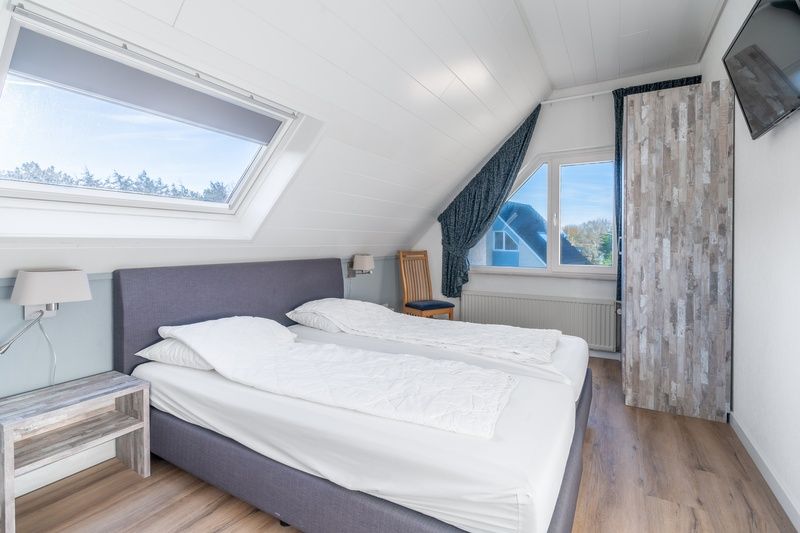 Attraktives Schlafzimmer im Ferienhaus Kamperfoelie 97, De Koog, Texel mit Blick auf die Natur der Watteninseln.