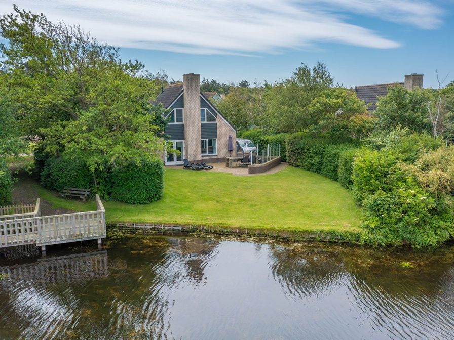 Vacation home Honeysuckle 55 in De Koog Texel overlooking green garden and water feature.