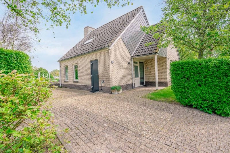 Entrance to Holiday home Honeysuckle 55 in De Koog Texel, surrounded by lush nature.