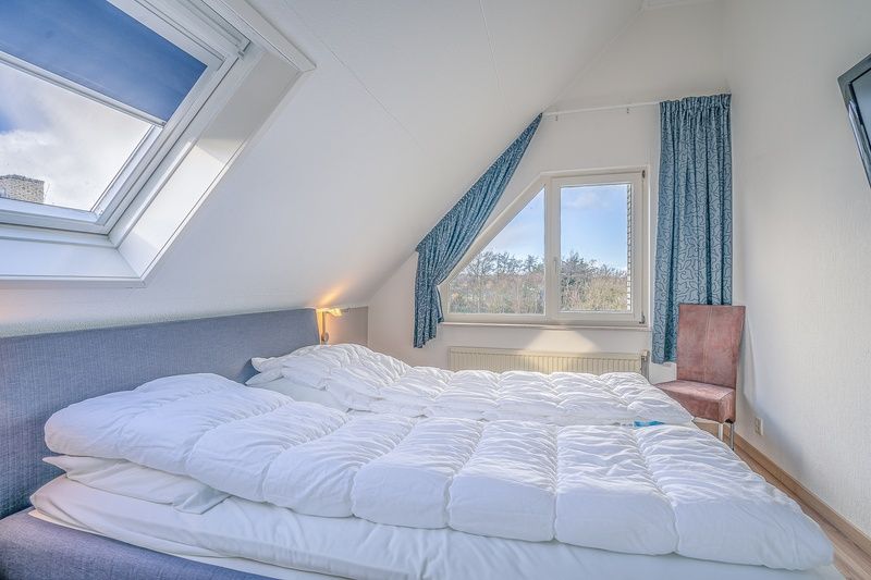 Comfortable bedroom in Holiday home Honeysuckle 55 Texel overlooking nature.
