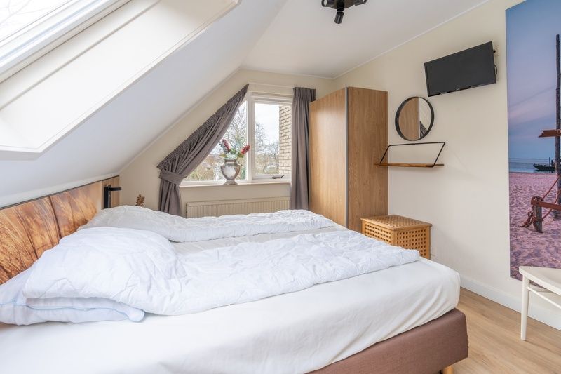 Schoenes Schlafzimmer mit Dachfenster im Ferienhaus Kamperfoelie 33, Texel.