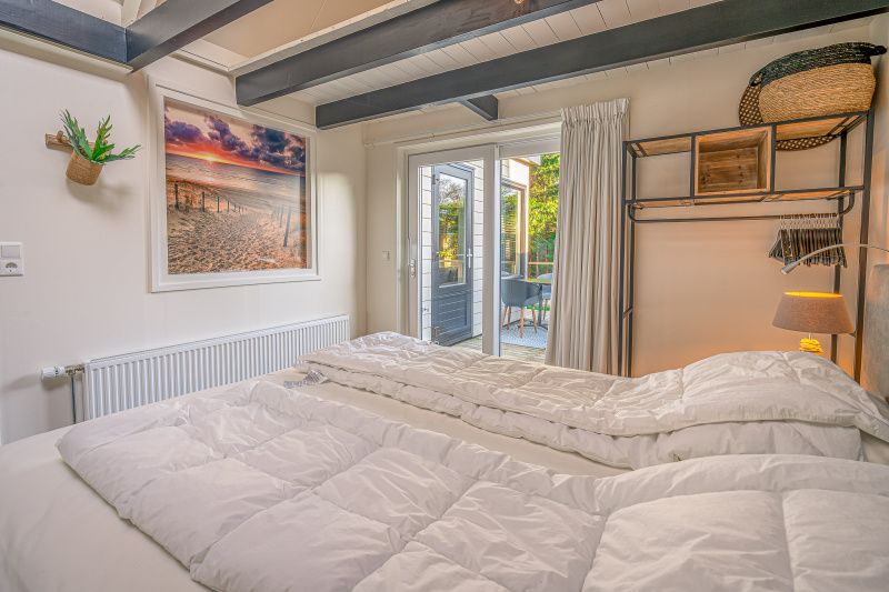 Luxurioeses Schlafzimmer mit Zugang zum Aussenbereich im Apartment Zee van Tijd, De Koog, Texel. Geniessen Sie Privatsphaere und Komfort.