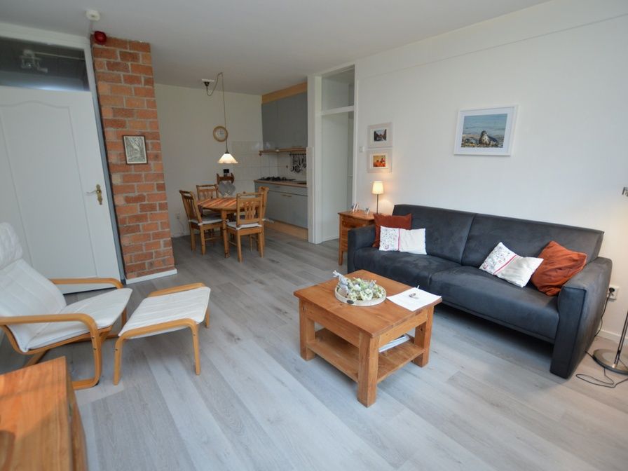 Cozy living room of Apartment Kerckeland 20 in De Koog, Texel with comfortable sitting area and dining area.