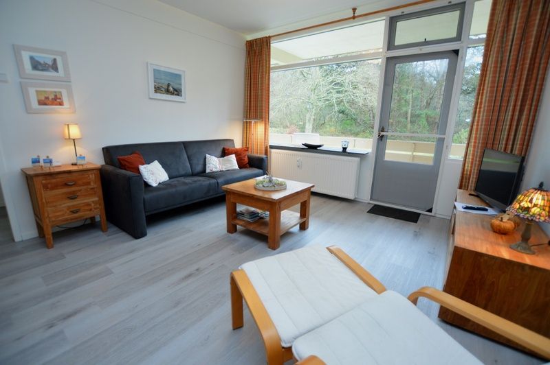 Stylish living room of Apartment Kerckeland 20 in De Koog, Texel with comfortable furniture and lots of light.