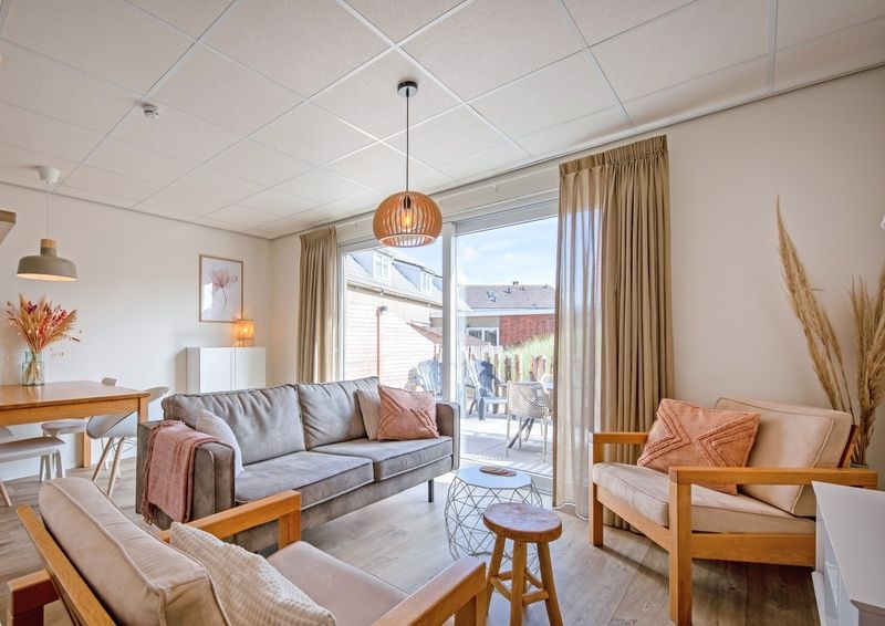 Cozy living room of De Duinroos in De Koog, Texel with comfortable sofas and lots of light.