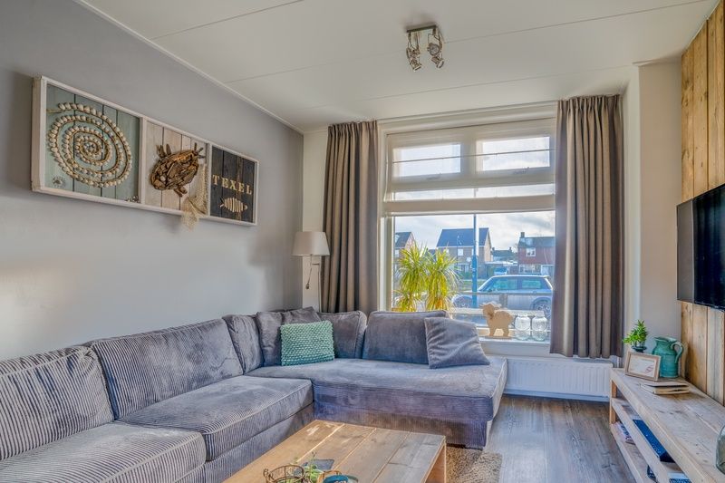 Cozy living room in De Bosruiter vacation home, De Koog Texel, with comfortable sofa and lots of natural light.