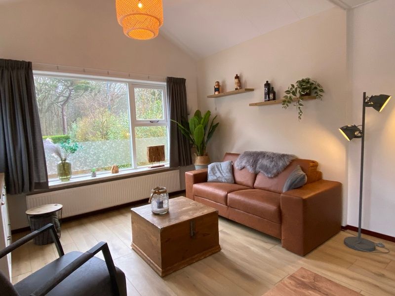 Helles Wohnzimmer des Ferienhauses Jutter in De Koog, Texel. Geraeumige Sitzecke mit viel Tageslicht und Aussicht.