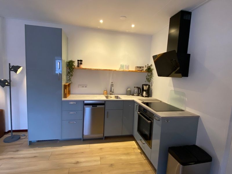 Stilvolle Kueche im Ferienhaus Jutter in De Koog, Texel. Moderne Geraete und viel Stauraum fuer einen sorglosen Aufenthalt.