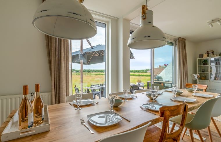 Dining area in Cottage in De Koog, Texel, overlooking green fields, Wadden Islands.