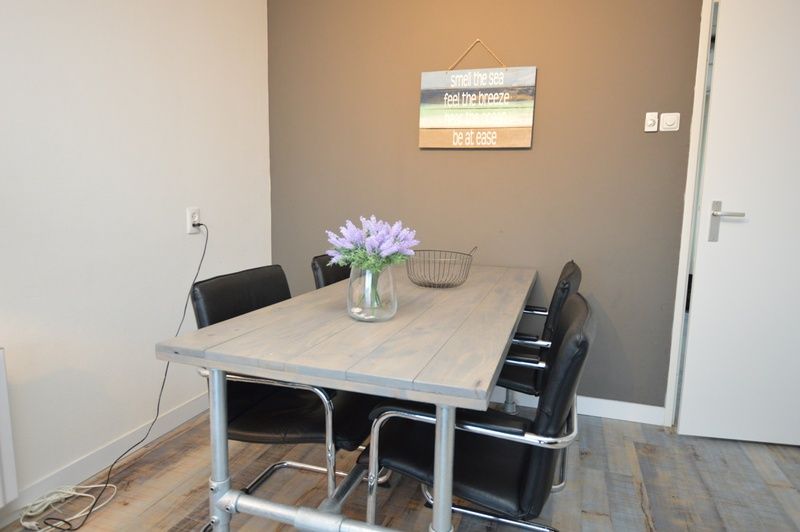 Stylish dining area in Motel Texel - Apartment 211/1P, De Koog, Texel, with flowers on the table.