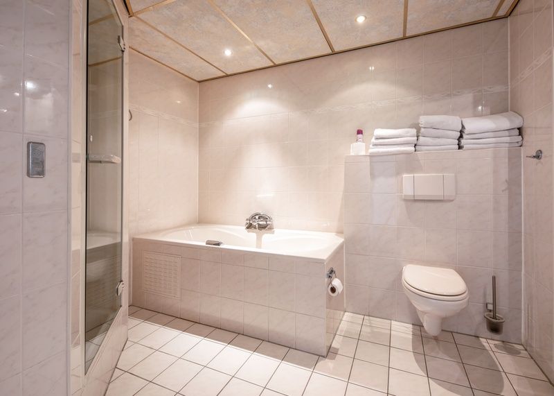 Spacious bathroom with bath and shower in Resort De Buteriggel Apartment 1, vacation home in De Koog, Texel.