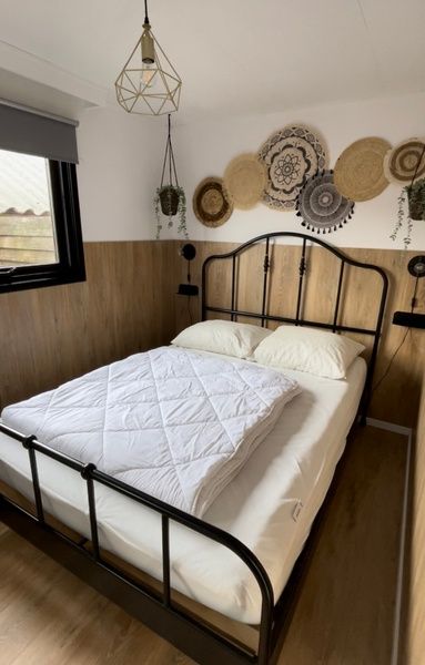 Gemuetliches Schlafzimmer im Chalet Bregkoog 253, De Koog, Texel mit bequemem Doppelbett und beruhigender Dekoration.