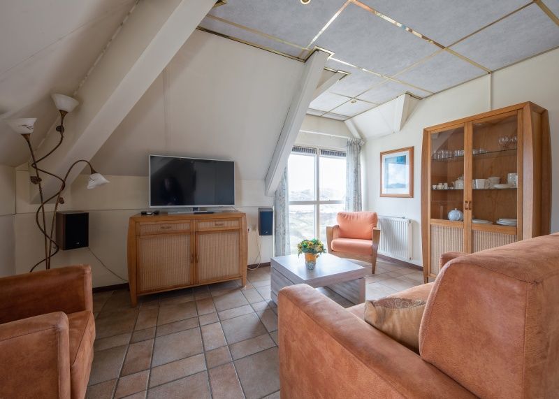 Gemuetliches Wohnzimmer des Resort De Buteriggel - Apartment 0 in De Koog, Texel mit komfortabler Sitzecke.