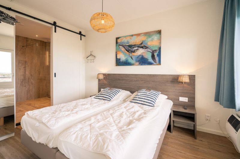 Comfortabele slaapkamer in Appartement Juliana 176 Eilandzicht, De Koog, Texel, met kunstwerk en rustgevend interieur.