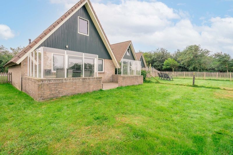 Gemuetliches Ferienhaus Nieuwlanderweg 77 in De Koog, Texel, mit gruener Umgebung und sonniger Terrasse fuer einen perfekten Urlaub auf den Watteninseln.