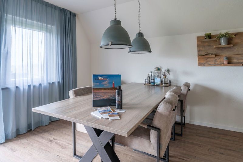 Modernes Esszimmer im Nieuwlanderweg 77, De Koog, Texel, mit grossem Tisch und bequemen Stuehlen, ideal fuer gemuetliche Mahlzeiten.