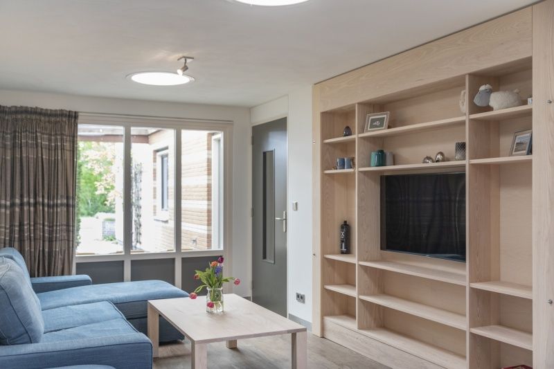 Helles Wohnzimmer in Orchismient 24, De Koog, Texel, mit grossen Fenstern und Einbauschrank.