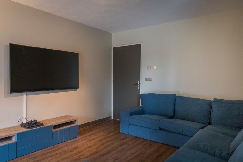 Gemuetliches Fernsehzimmer im Ferienhaus Orchismient 24, De Koog, Texel, mit bequemem Sofa und Flachbildfernseher.