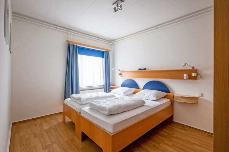 Bright bedroom with double bed in Orchismient 55 vacation home De Koog Texel.
