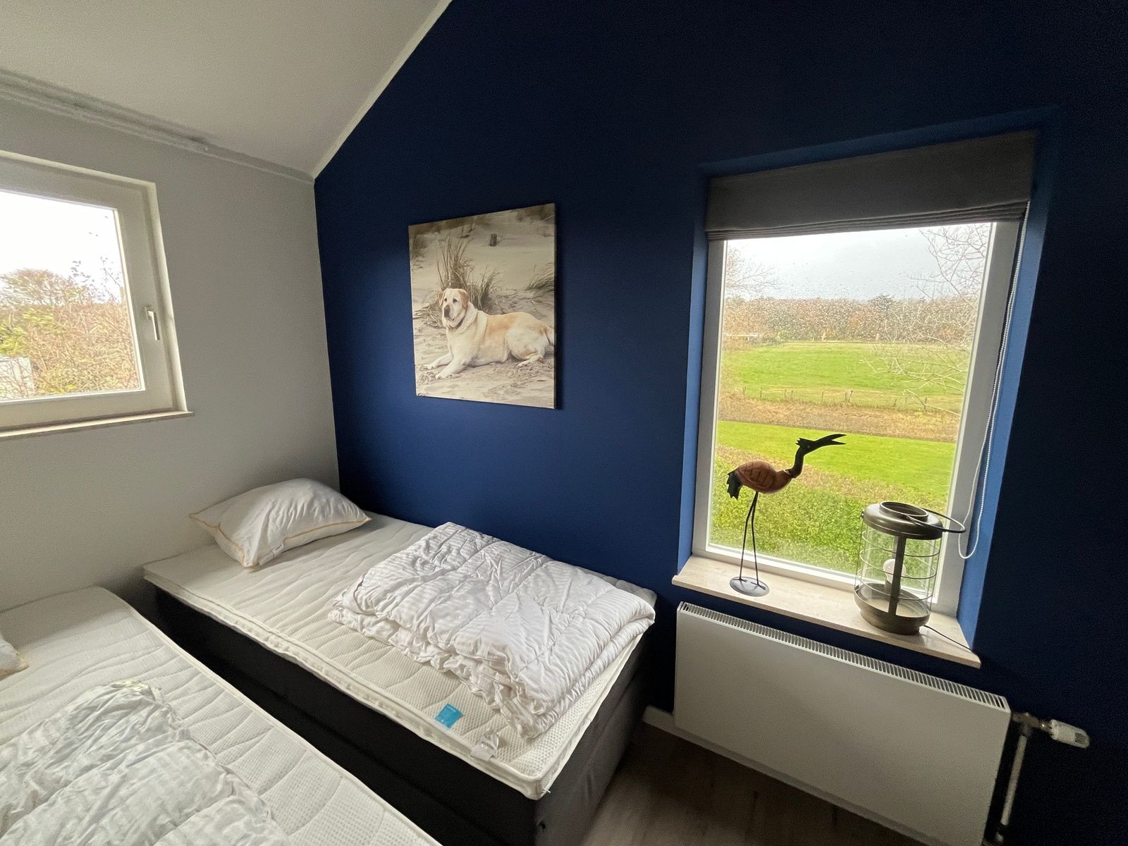 Slaapkamer met prachtig uitzicht op de natuur in De Duinven, De Koog, Texel, biedt een serene omgeving.
