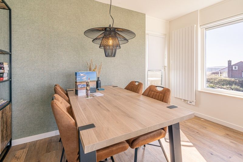 Essecke im Appartement Juliana 150 Zeezicht, De Koog Texel, mit Blick auf die Duenen und das Meer.