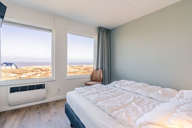 Schlafzimmer mit Meerblick in Appartement Juliana 150 Sea View, De Koog Texel, fuer einen entspannten Aufenthalt.