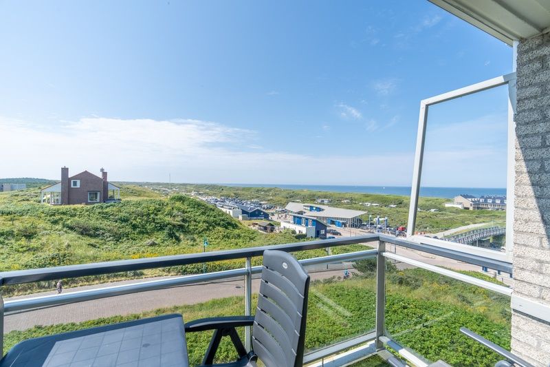 Balkon mit Blick auf das Meer und die Duenen im Apartment Juliana 150 Zeezicht, De Koog Texel, ein idealer Ort zum Entspannen.