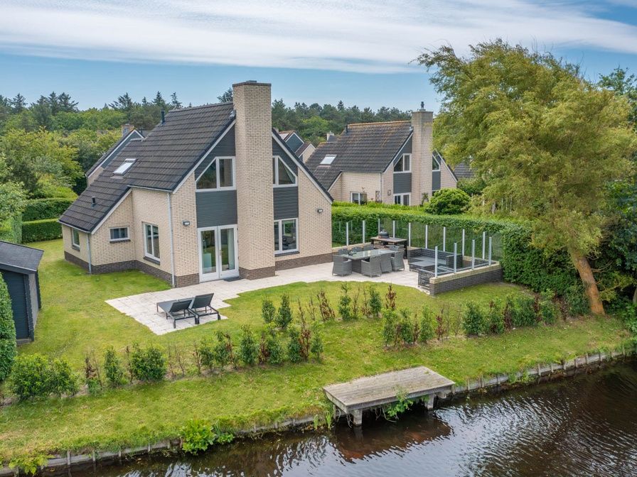 Vacation home Honeysuckle 67 in De Koog Texel with spacious garden and terrace on the water, ideal for relaxation on the Wadden Islands.