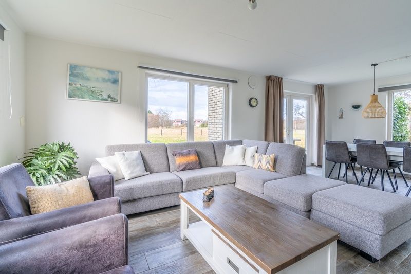 Modern living room of Holiday home Honeysuckle 67 in De Koog Texel with comfortable seating area and lots of natural light on the Wadden Islands.