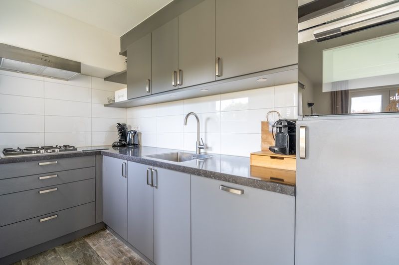 Fully equipped kitchen in Holiday home Honeysuckle 67 De Koog Texel with modern appliances and sleek finish on the Wadden Islands.